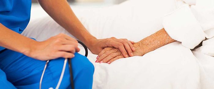 provider comforting patient by holding their hand