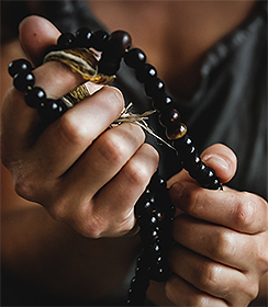 close up of hands holding black beads